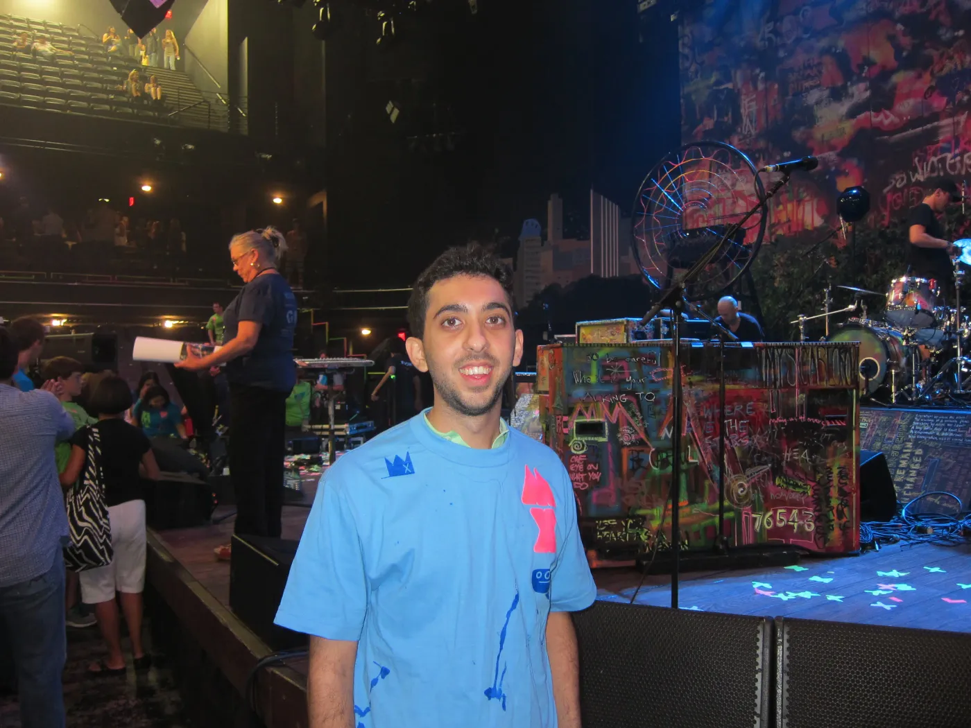 Jimmy Dushku wearing a glow-in-the-dark Mylo Xyloto t-shirt in front of the stage