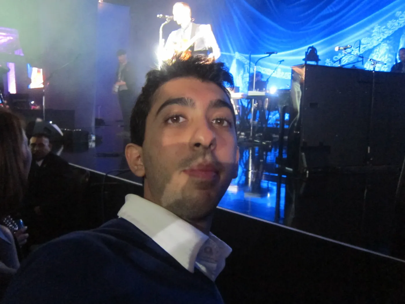 Jimmy Dushku taking a selfie with Chris Martin performing on stage behind him