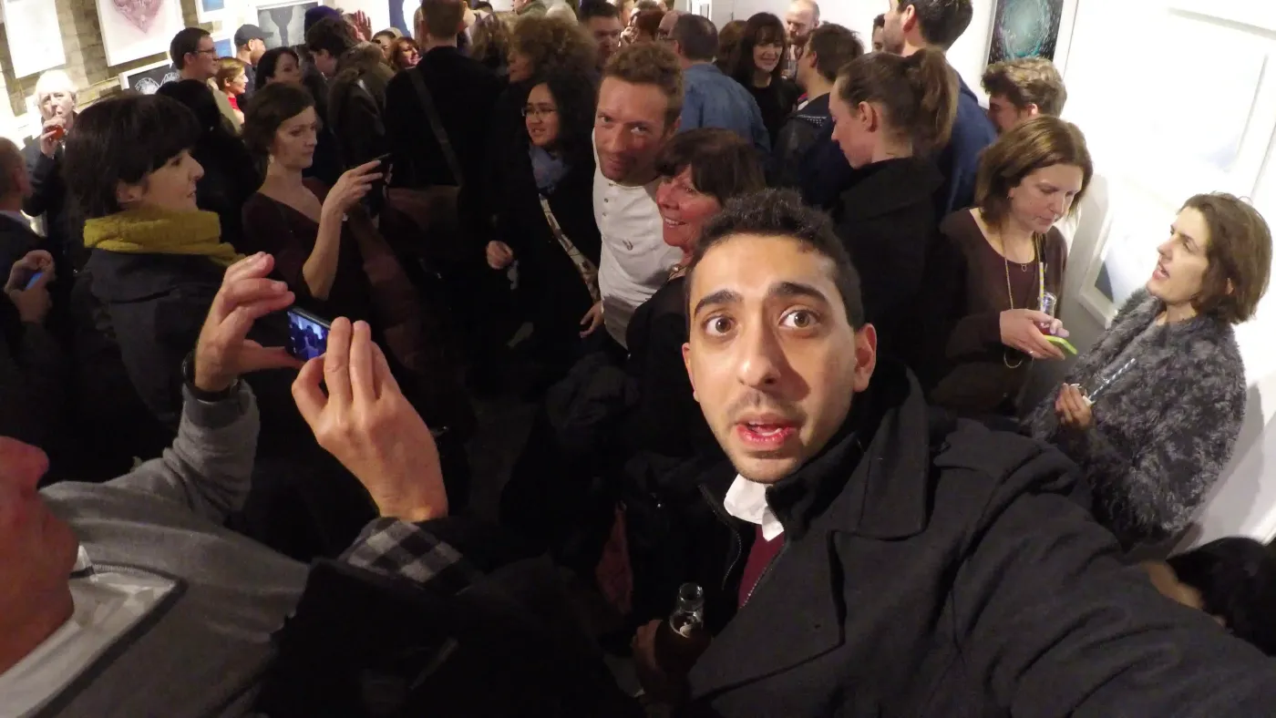 Jimmy Dushku taking a selfie in a crowd with Chris Martin looking directly into the camera in the background