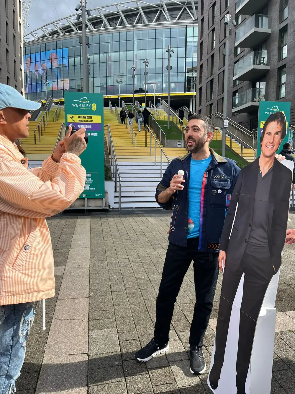 Jimmy Dushku and a cardboard cutout of Tom Cruise being interviewed outside Wembley Stadium before the show