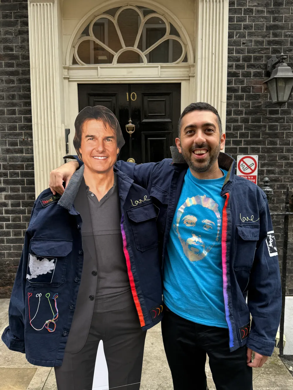 Jimmy Dushku posing with a cardboard cutout of Tom Cruise outside the fake 10 Downing Street door in London