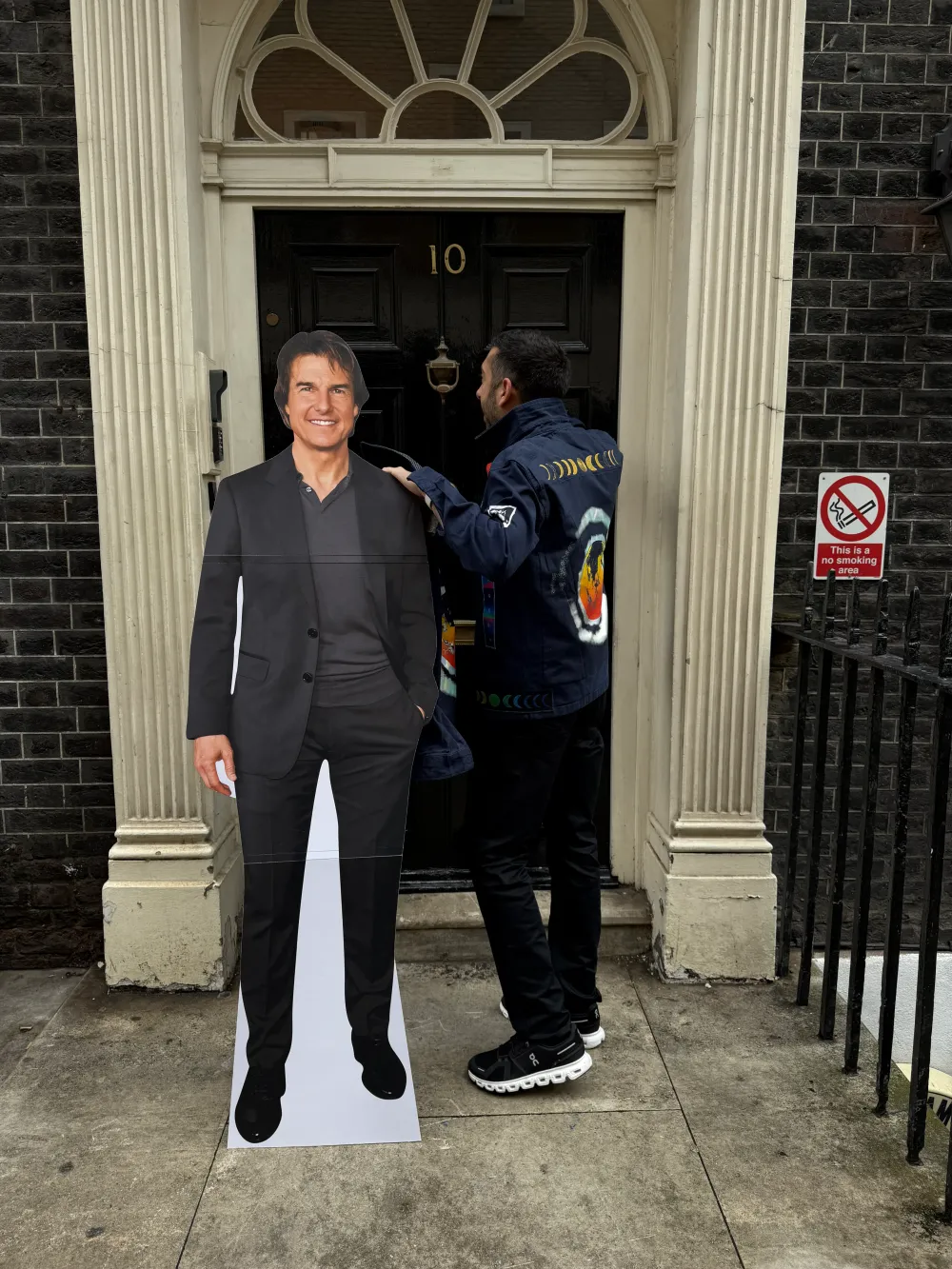 Jimmy Dushku knocking on the fake 10 Downing Street door with a cardboard cutout of Tom Cruise