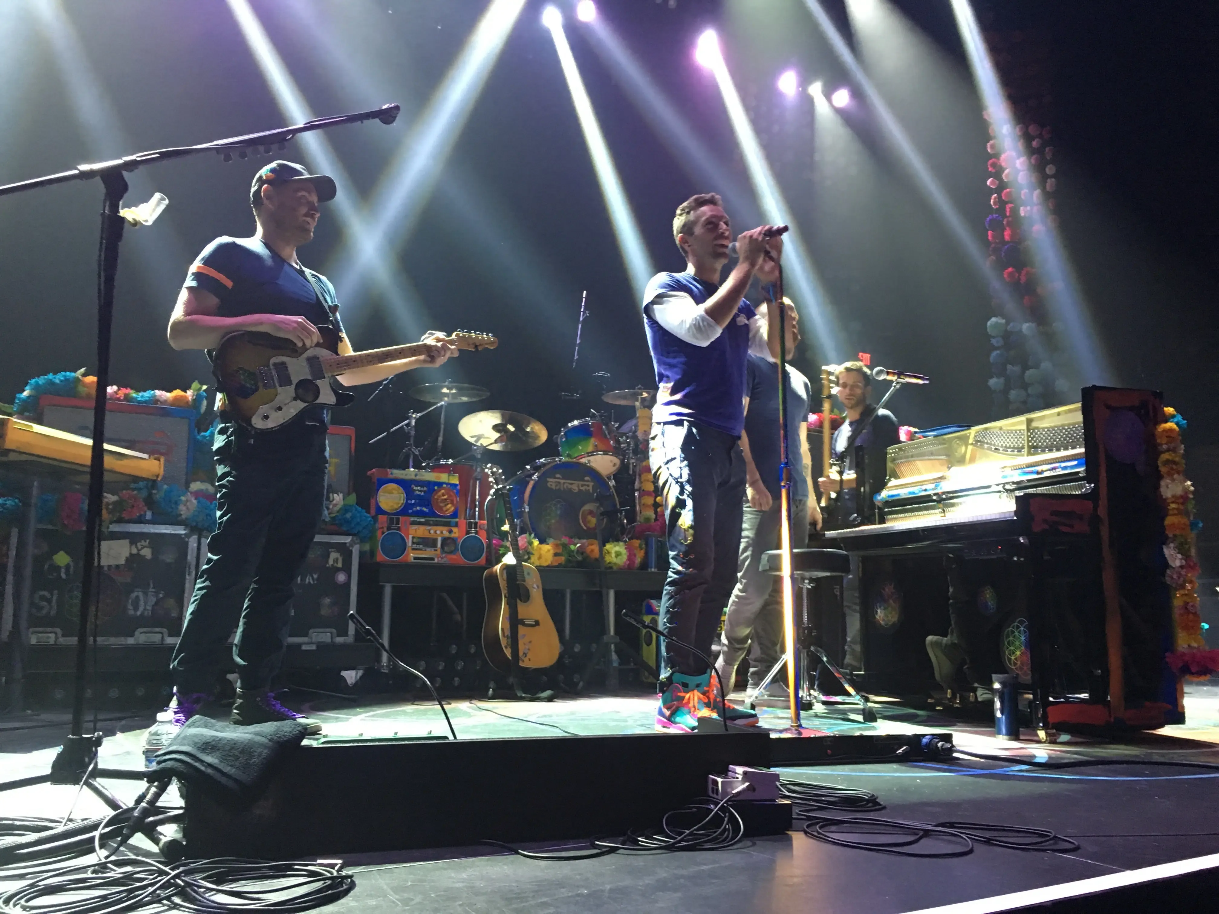 Chris Martin and Jonny Buckland performing an acoustic set on stage at the Belasco Theatre