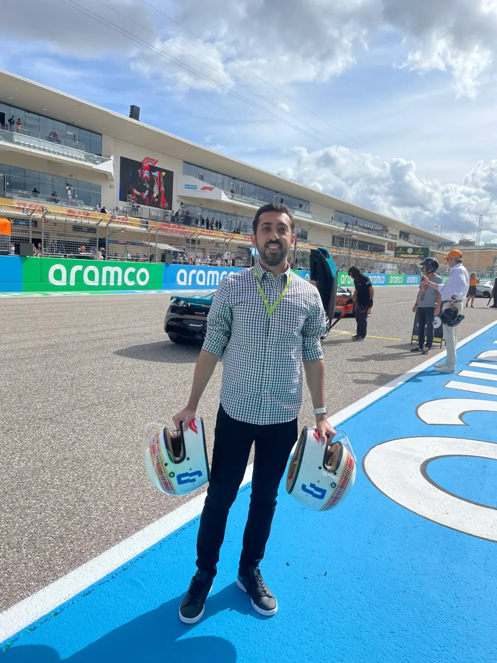 Jimmy Dushku standing on the grid holding both tartan Race Against Dementia helmets
