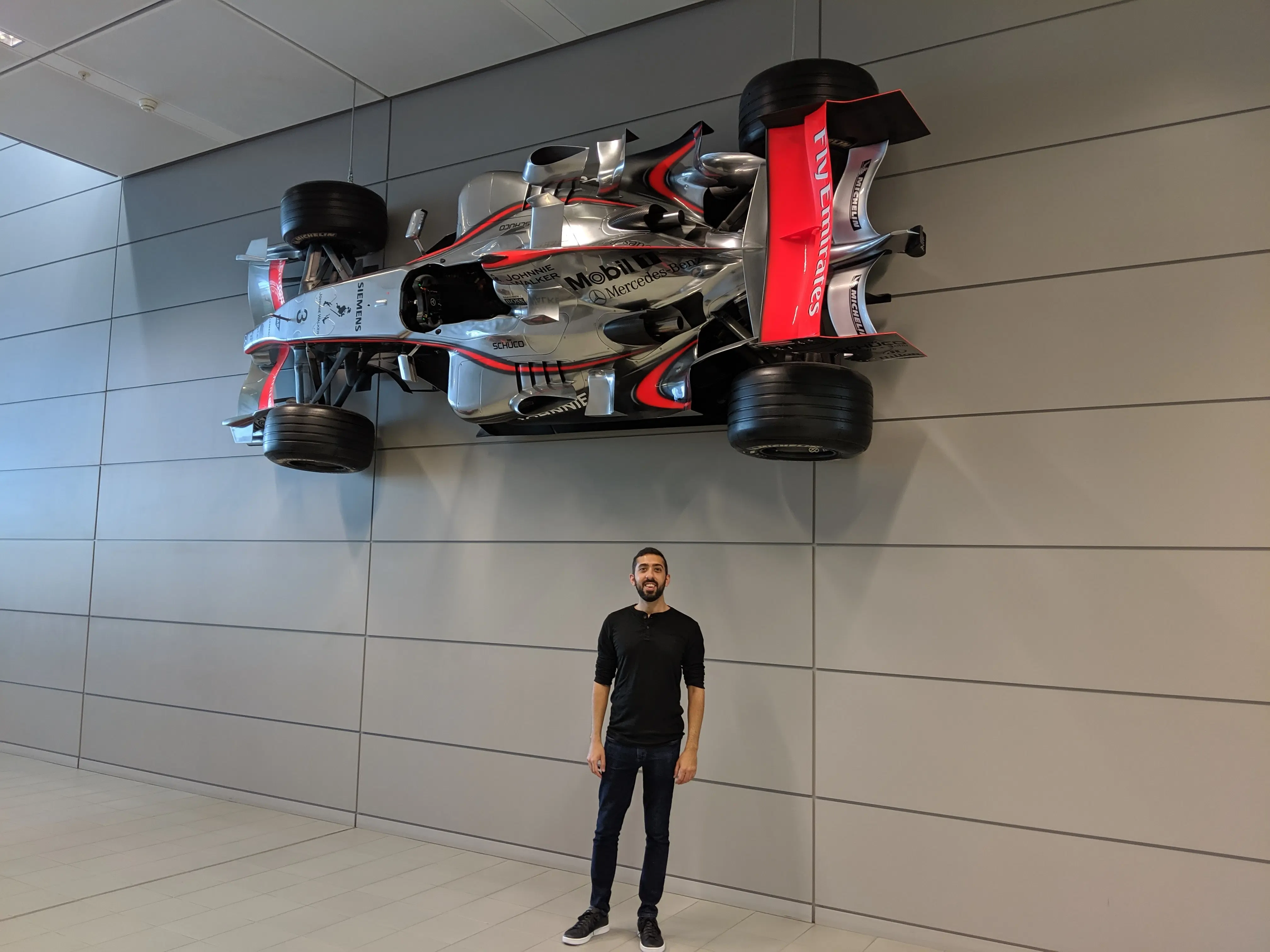 Standing underneath one of the cars mounted on the wall