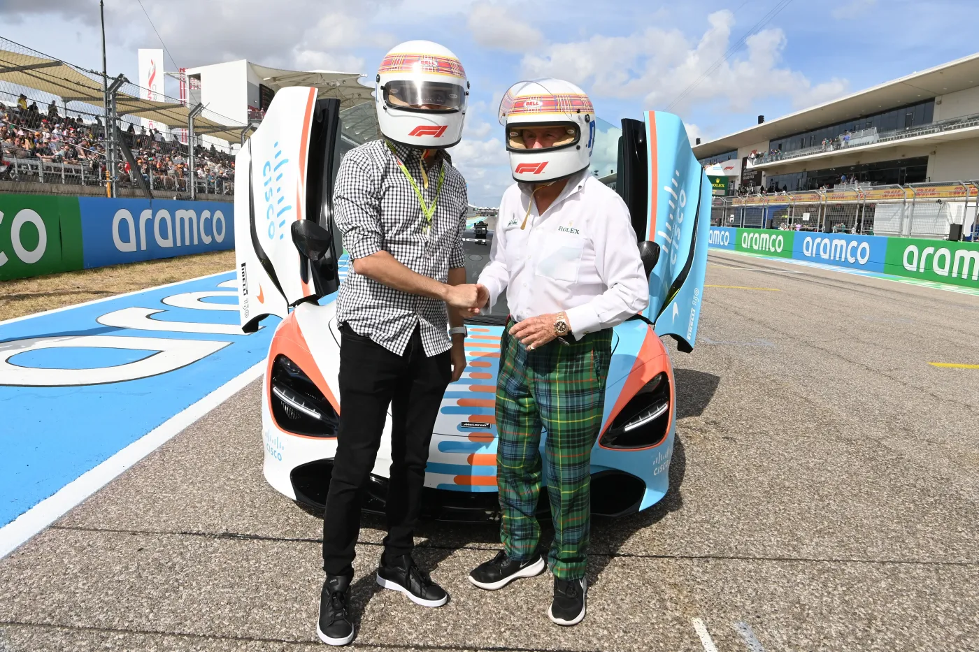 Jimmy Dushku and Sir Jackie Stewart wearing helmets in front of a McLaren 720S before the hot lap