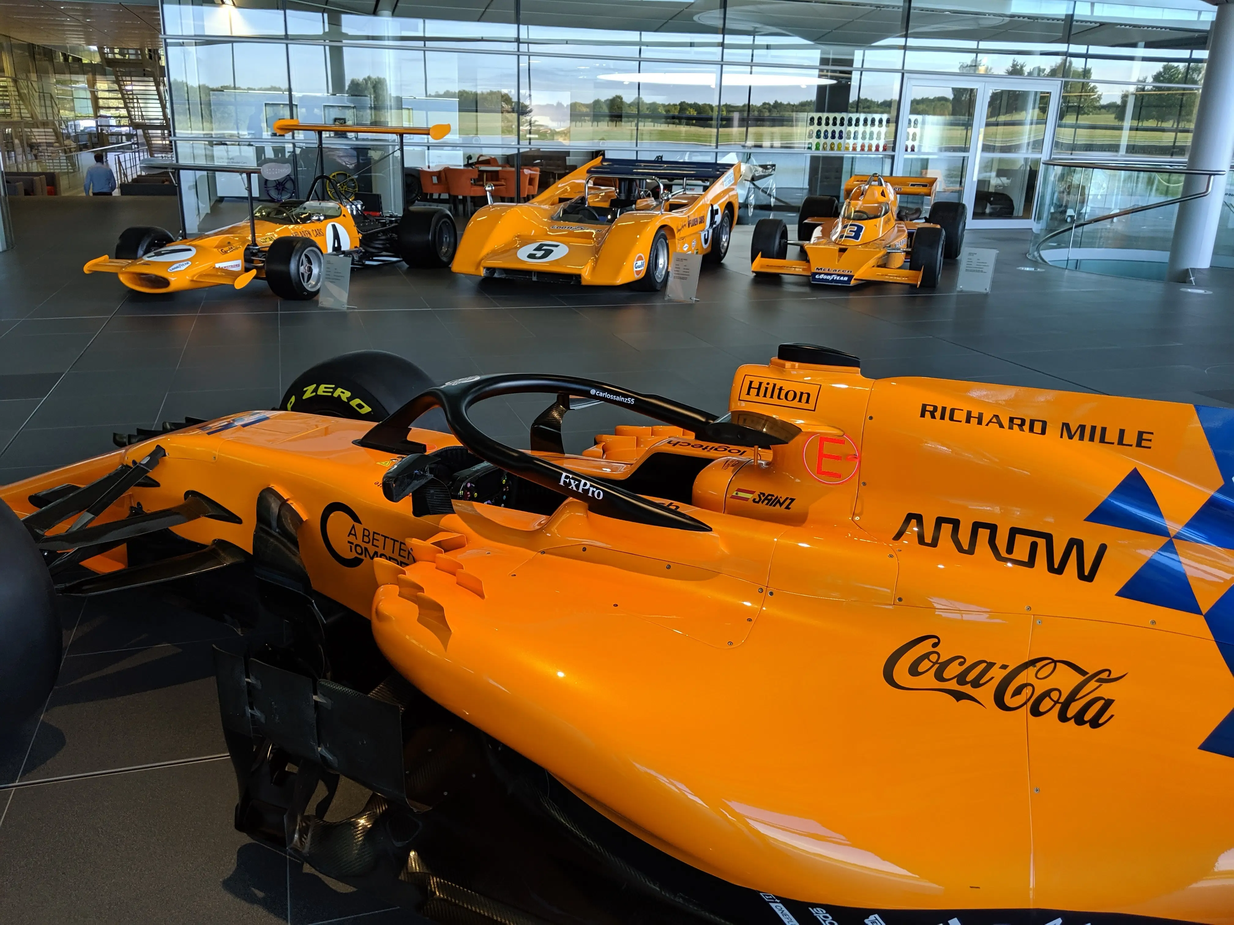 A row of historic McLaren Formula 1 race cars on display inside the Technology Centre