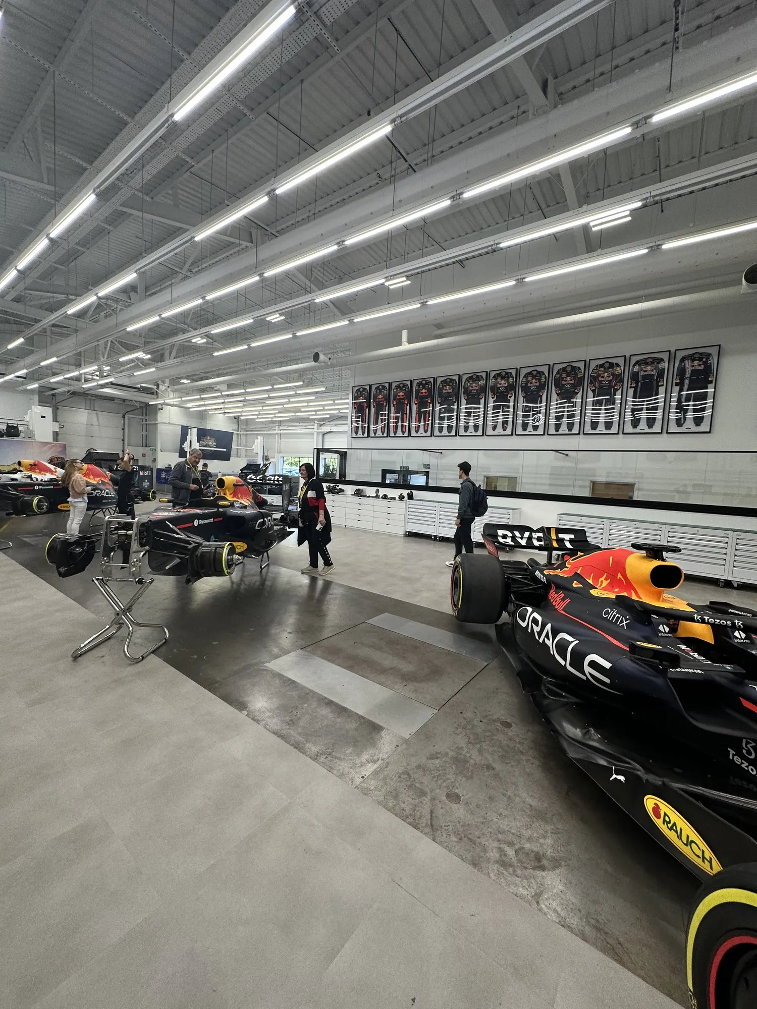 Inside the garage, RB7 and modern regulation cars, and race suits on the wall